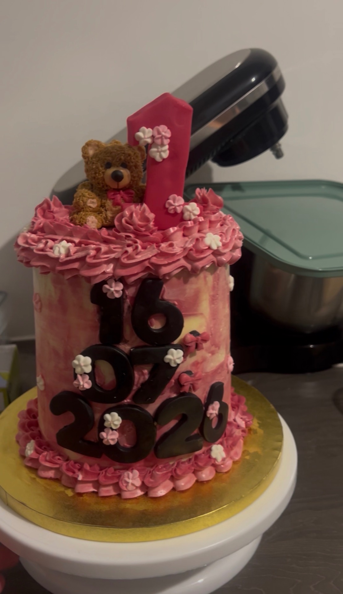 Pink 16th birthday cake with teddy bear, candle and floral decorations
