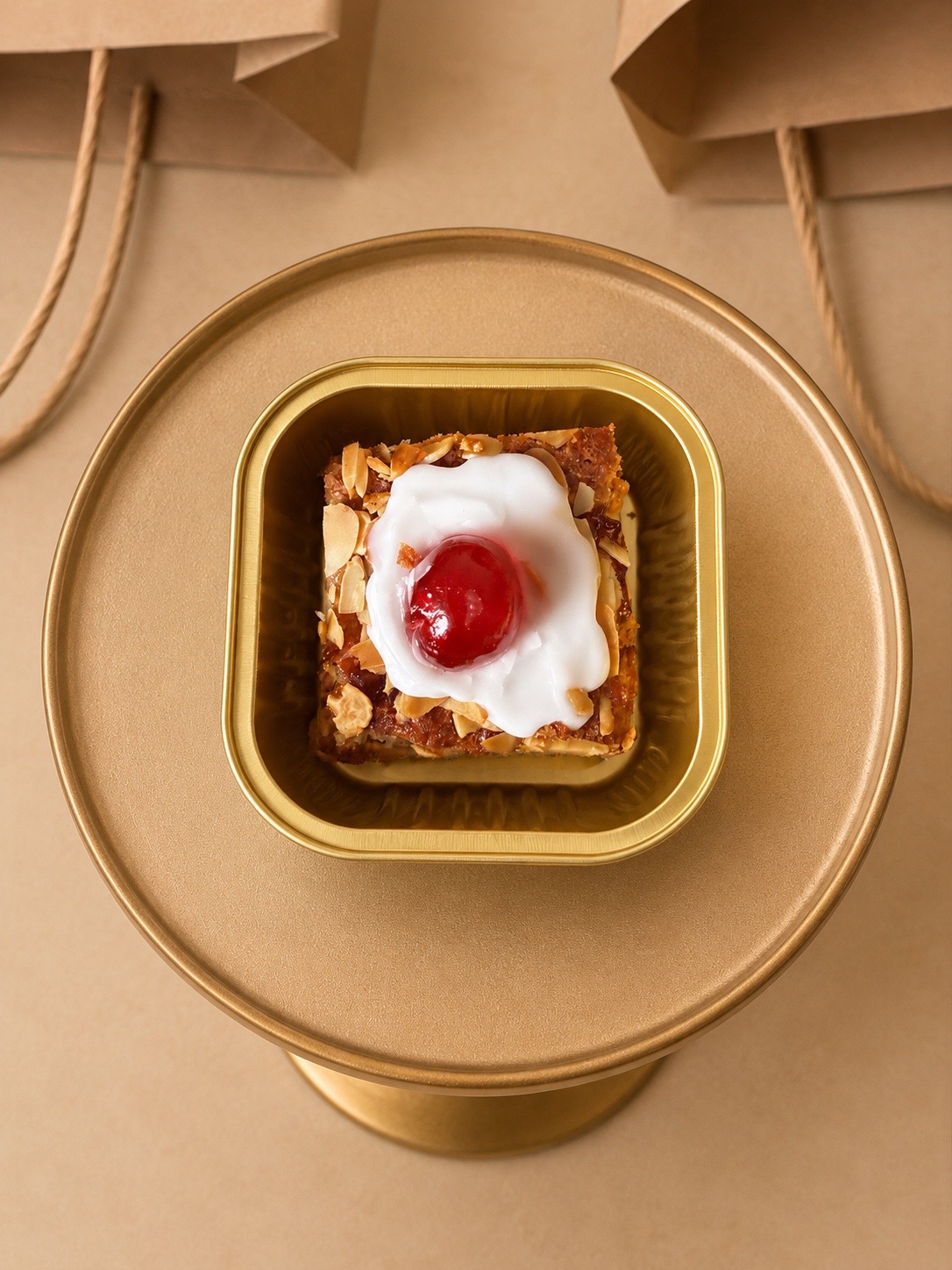 Cherry bakewell brownie with icing, almonds and a glacé cherry